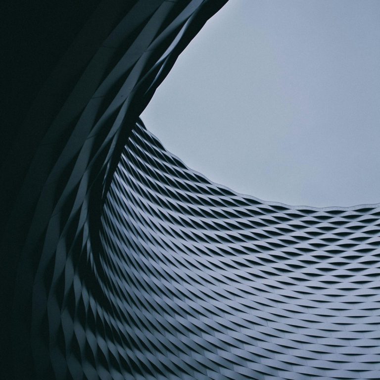 Bild einer Kurve als abstraktes Bild. Das um die kurve gehendes Material hat eine Struktur und wirkt daher industriell-futuristisch