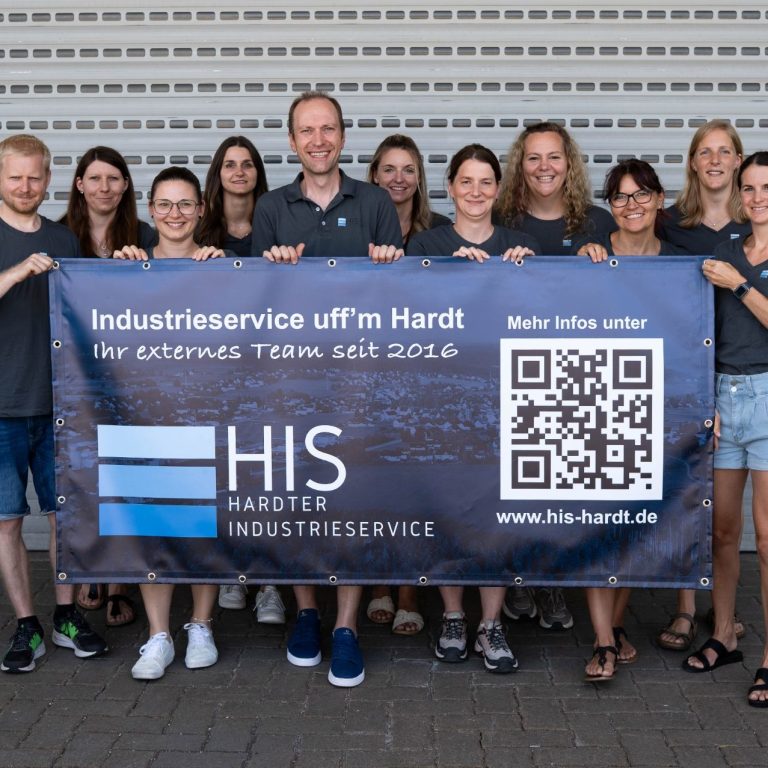 Das Team der HIS Das Team der HIS steht vor der neuen Halle und hält einen Banner mit Eigenwerbung